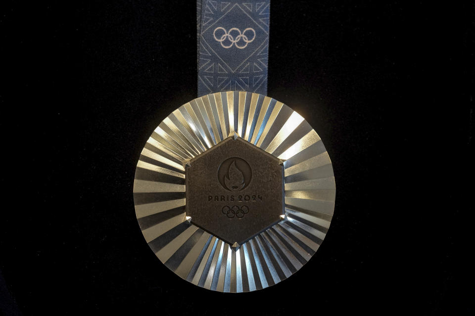 The Paris 2024 Olympic silver medal is presented to the press, in Paris, Thursday, Feb. 1, 2024. A hexagonal, polished piece of iron taken from the Eiffel Tower is being embedded in each gold, silver and bronze medal that will be hung around athletes' necks at the July 26-Aug. 11 Paris Games and Paralympics that follow. (AP Photo/Thibault Camus)