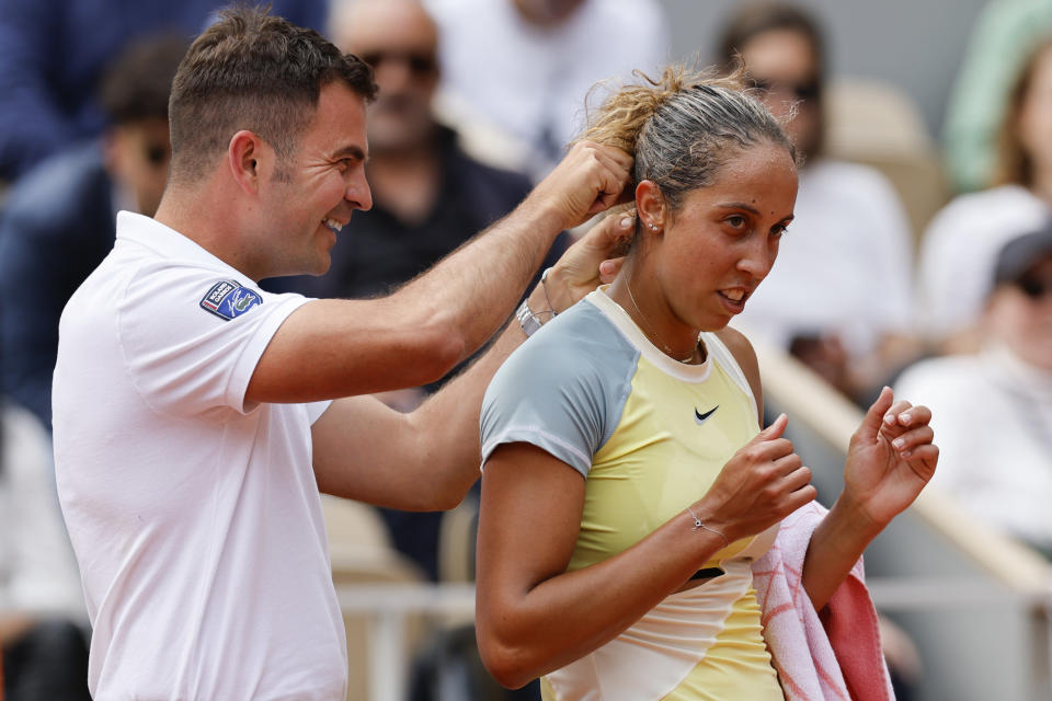 Chair umpire Jaume Campistol helped Madison Keys of the U.S. to untangle her necklace which got stuck in her hair during the second round match against France's Caroline Garcia at the French Open tennis tournament in Roland Garros stadium in Paris, France, Thursday, May 26, 2022. (AP Photo/Jean-Francois Badias)