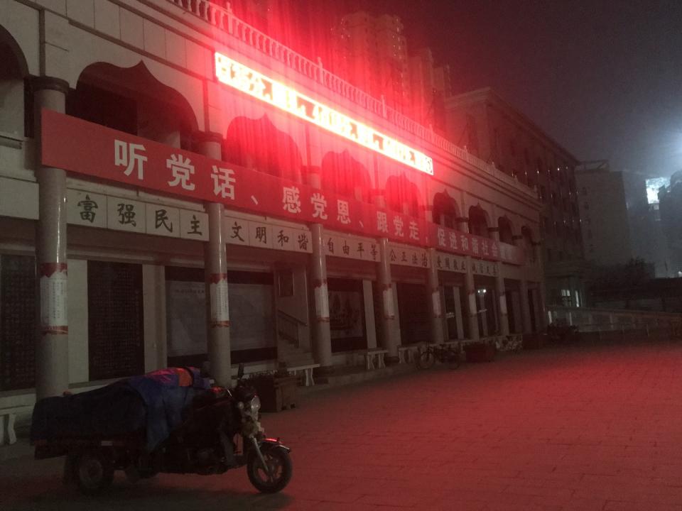 A banner reads: "Listen to the Party, give thanks to the Party, follow the Party, build harmonious society."