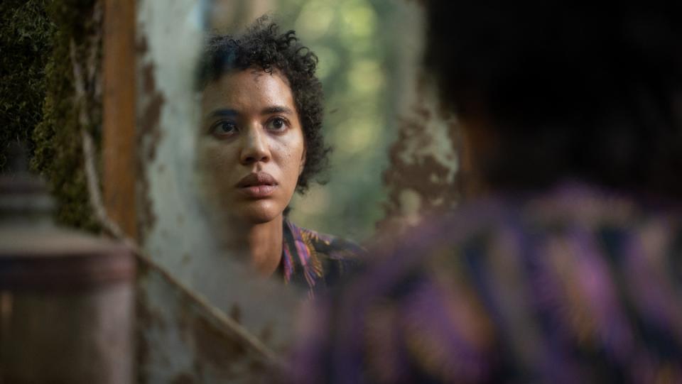 jasmin savoy brown as teen tai turner looks into a mirror at her new haircut yellowjackets