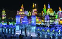Workers and scaffoldings are seen next to newly-built ice sculptures illuminated by coloured lights ahead of the 30th Harbin Ice and Snow Festival, in Harbin, Heilongjiang province December 26, 2013. According to the festival organizers, nearly 10,000 workers were employed to build the ice and snow sculptures, which require about 180,000 square metres of ice and 150,000 square metres of snow. The festival kicks off on January 5, 2014. Picture taken December 26, 2013. REUTERS/Sheng Li (CHINA - Tags: ENVIRONMENT SOCIETY BUSINESS EMPLOYMENT TRAVEL TPX IMAGES OF THE DAY) CHINA OUT. NO COMMERCIAL OR EDITORIAL SALES IN CHINA