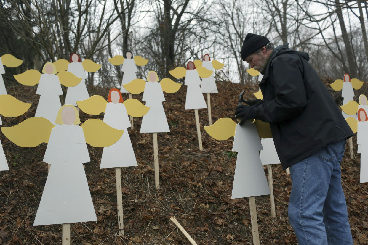 Eric Mueller coloca un ángel de madera por cada víctima de la masacre en la Escuela Primaria Sandy Hook frente a su casa en Newtown, Connecticut. (Michael Appleton/The New York Times)
