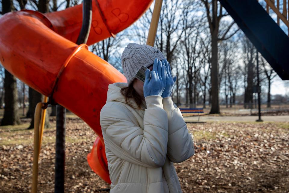 Madison Brown, 23, covers her face as she cries after two Secret Santa elves each hand her $100 bills during the annual Secret Santa in Lincoln Park on Thursday, Dec. 14, 2023.