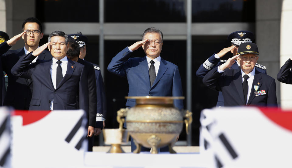 South Korean President Moon Jae-in, center, salutes during the repatriation ceremony for the remains of 64 South Korean soldiers killed in North Korea during the Korean War, which arrived at Seoul Air Base in Seongnam, South Korea, from Hawaii on Monday, Oct. 1, 2018. They were earlier found in North Korea during a joint 1996-2005 excavation project between the United States and North Korea before forensic identification tests in Hawaii confirmed they belong to South Korean war dead, according to Seoul's Defense Ministry. (Bae Jae-man/Yonhap via AP)