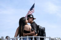 FILE - In this June 15, 2021, file photo, Silvia Guillen, 19, and her boyfriend Joseph Alvarez, 22, both from El Paso, Texas, share a kiss at Universal Studios in Universal City, Calif. COVID-19 deaths in the U.S. have dipped below 300 a day for the first time since the early days of the disaster in March 2020, while the number of Americans fully vaccinated has reached about 150 million. (AP Photo/Ringo H.W. Chiu, File)