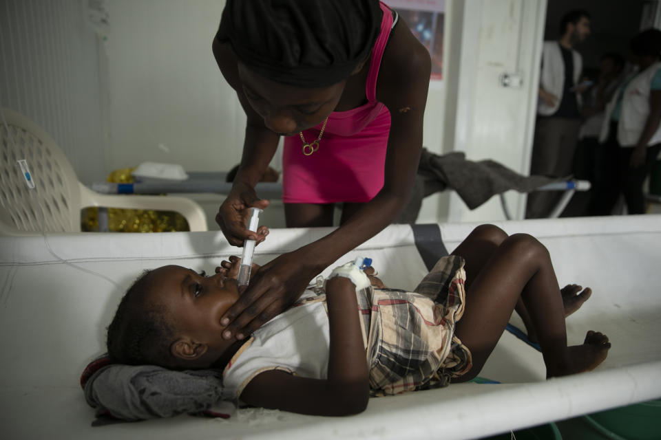 A girl with cholera symptoms is helped by her mother at a clinic run by Doctors Without Borders, in the Delmas neighborhood of Port-au-Prince, Haiti, Thursday, Nov. 10, 2022. Across Haiti, many patients are dying because say they’re unable to reach a hospital in time, health officials say. (AP Photo/Odelyn Joseph)