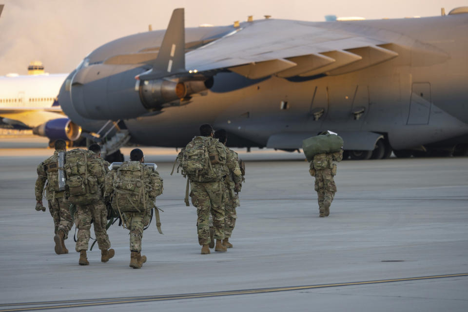 Members of the 82nd Airborne Division of the U.S. Army walk on the tarmac at Pope Field ahead of deployment to Poland from Fort Bragg, N.C. on Monday, Feb. 14, 2022. They are among soldiers the Department of Defense is sending in a demonstration of American commitment to NATO allies worried at the prospect of Russia invading Ukraine.  (AP Photo/Nathan Posner)