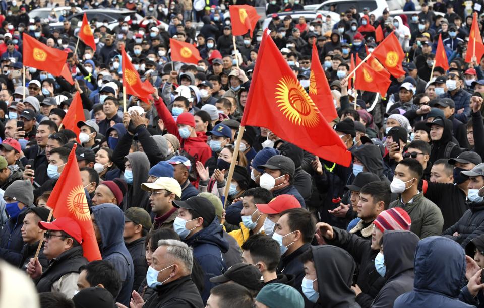 People protest during a rally on the central square in Bishkek, Kyrgyzstan, Friday, Oct. 9, 2020. Sooronbai Jeenbekov, the embattled president of Kyrgyzstan, has moved to end the political turmoil that followed a disputed parliamentary election, ordering a state of emergency in the capital. Jeenbekov has faced calls to resign by protesters who stormed government buildings after Sunday’s parliamentary vote was reportedly swept by pro-government parties. Protesters freed former President Almazbek Atambayev, who was jailed on charges seen by his supporters as a political vendetta. (AP Photo/Vladimir Voronin)