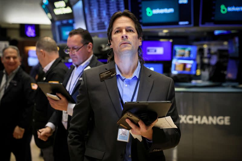 FILE PHOTO: Traders work on the floor of the NYSE in New York