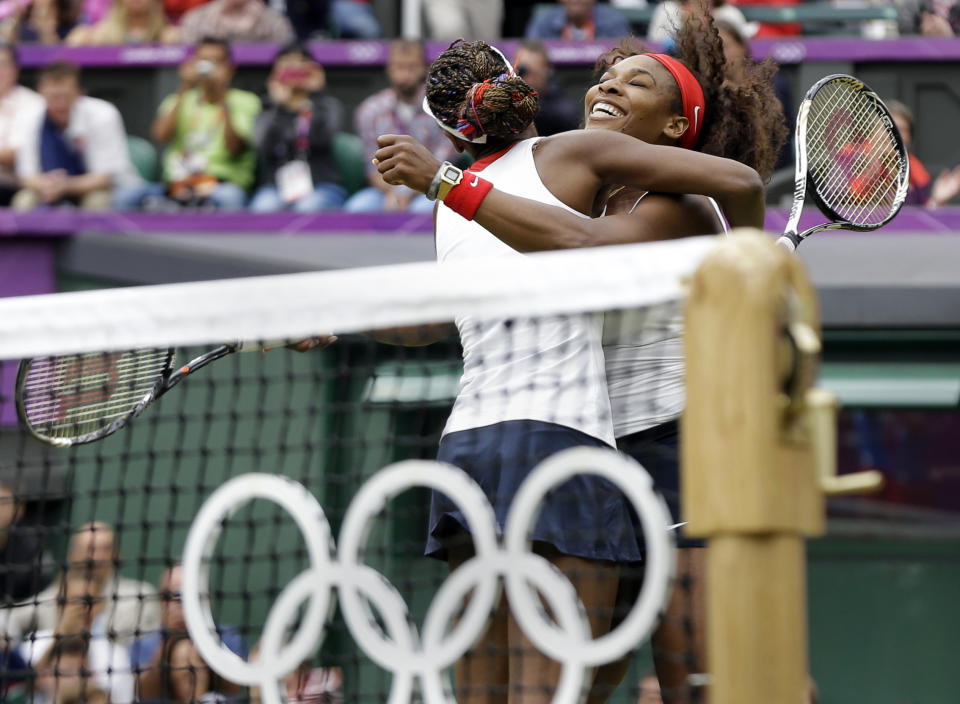 FILE - This photo by Associated Press photographer Elise Amendola shows Serena Williams, right, and her sister Venus Williams celebrating their victory in the gold medal women's doubles match at the All England Lawn Tennis Club in Wimbledon, London at the 2012 Summer Olympics. Amendola, who recently retired from the AP, died Thursday, May 11, 2023, at her home in North Andover, Mass., after a 13-year battle with ovarian cancer. She was 70. (AP Photo/Elise Amendola, File)