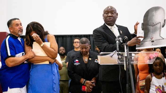 Attorney Ben Crump (right) holds up a diagram explaining Jalen Ja’Von Randle’s gunshot wound aside grieving kin during a news conference last month in Houston. Randle was fatally shot after an altercation with police officers on April 27. (Photo: Brandon Bell/Getty Images)