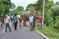 KAZIRANGA, INDIA - JULY 18, 2020: Forest official stand guard on NH-37 after a a rhino rests near NH 37 after straying out from flood-affected Kaziranga National Park, in Nagaon district of Assam ,India - PHOTOGRAPH BY Anuwar Ali Hazarika / Barcroft Studios / Future Publishing (Photo credit should read Anuwar Ali Hazarika/Barcroft Media via Getty Images)