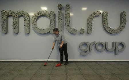 A woman sweeps in front of the logo of Russian Internet group Mail.ru at its headquarters in Moscow, Russia, April 5, 2016. REUTERS/Maxim Shemetov