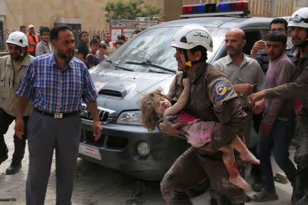 A civil defence member carries an injured girl after an airstrike in the rebel-controlled city of Idlib, Syria. REUTERS/Ammar Abdullah