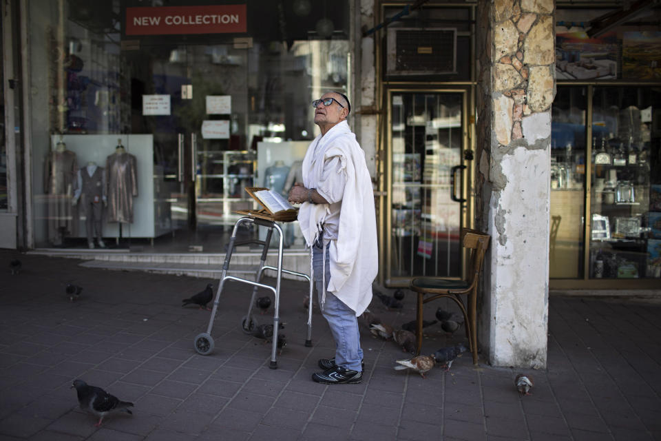 Image: A man prays next to his house in Bnei Brak last week. (Oded Balilty / AP)