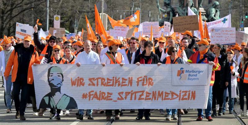 Doctors from Bavarian university hospitals take part in a protest march through the city center with placards reading "We are striking for #fairtopmedicine" as part of a strike aim to increase the pressure on the Collective Bargaining Association of German States in the wage negotiations. Peter Kneffel/dpa