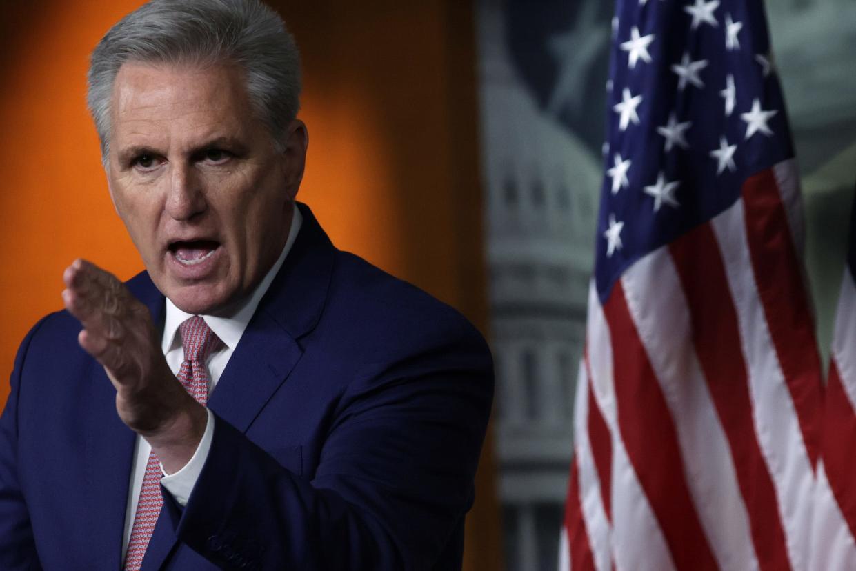 House Minority Leader Kevin McCarthy, his left hand slicing through air, speaks to reporters during a Capitol Hill press conference.