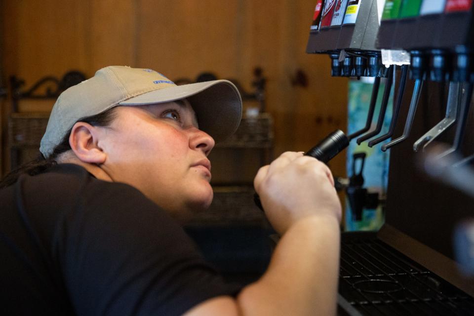 Joanie Garza, a public health inspector with the city, checks soda fountain nozzles for mold and other contaminants during a restaurant inspection on June, 6 2023, in Corpus Christi, Texas.