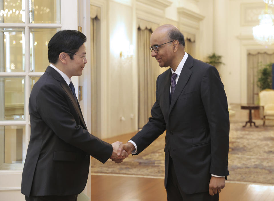In this photo released by Singapore's Ministry of Communications and Information, Singapore President Tharman Shanmugaratnam, right, greets Singapore's Deputy Prime Minister Lawrence Wong at the Istana in Singapore, Monday, May 13, 2024. (Mohd Fyrol/Ministry of Communications and Information via AP)
