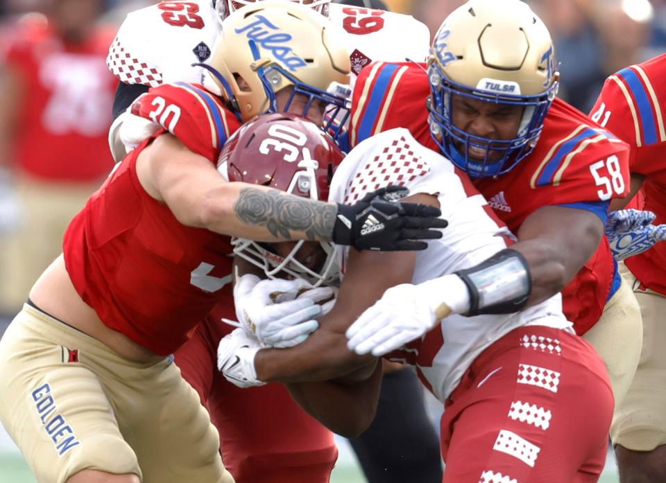 Tulsa's Justin Wright, left, and Elijah Taylor stop Temple's Ra'Von Bonner during their game Saturday in Tulsa, Okla.