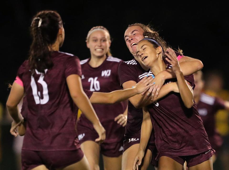 Walsh Jesuit's Hannah Pachan, front right, is mobbed by teammates after tying up the score against Strongsville during the second half of a soccer game, Wednesday, Aug. 24, 2022, in Cuyahoga Falls, Ohio.