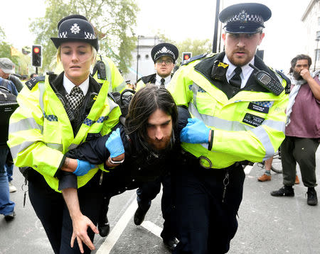 Members of the police carry a demonstrator during the Extinction Rebellion protest at the Marble Arch in London, Britain April 24, 2019. REUTERS/Toby Melville