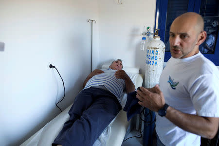 Volunteer cardiologist of the Aegean Team Nikos Patsourakos (R), 45, examines local Kostas Amorgianos on the islet of Thymaina, Greece, May 11, 2017. REUTERS/Alkis Konstantinidis