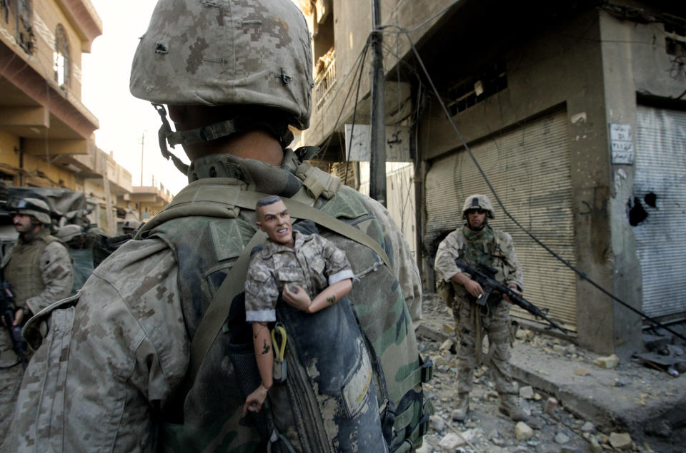 FILE - In Sunday, Nov. 14, 2004 file photo made by Associated Press photographer Anja Niedringhaus, a U.S. Marine of the 1st Division carries a mascot for good luck in his backpack as his unit pushed further into the western part of Fallujah, Iraq. Niedringhaus, 48, an internationally acclaimed German photographer, was killed and AP reporter Kathy Gannon was wounded on Friday, April 4, 2014 when an Afghan policeman opened fire while they were sitting in their car in eastern Afghanistan. (AP Photo/Anja Niedringhaus, File)