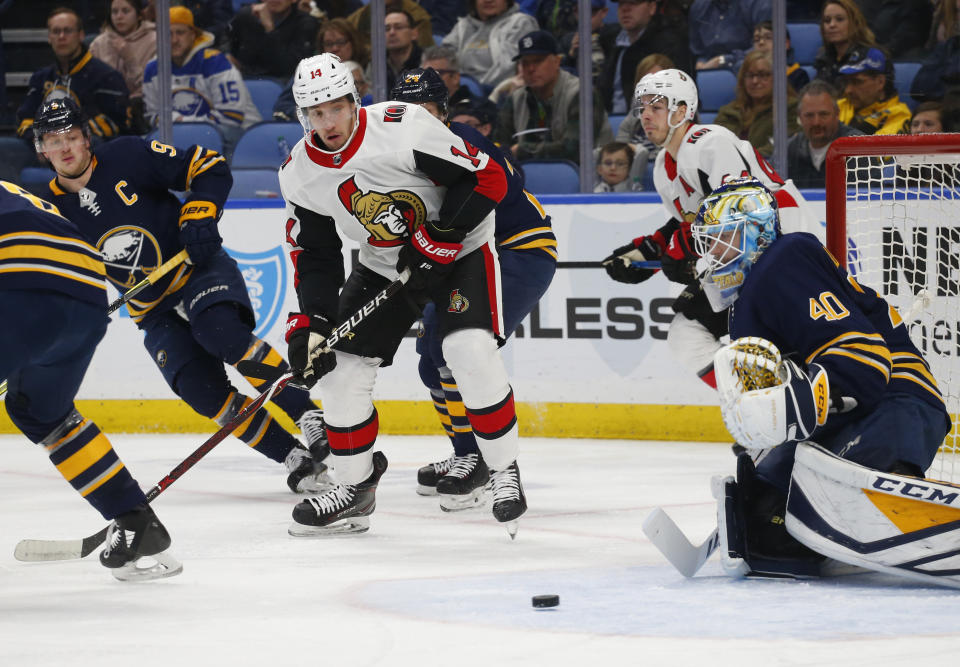 Buffalo Sabres goalie Carter Hutton (40) and Ottawa Senators forward Max Veronneau (14) watch the puck during the second period of an NHL hockey game Thursday, April 4, 2019, in Buffalo, N.Y. (AP Photo/Jeffrey T. Barnes)