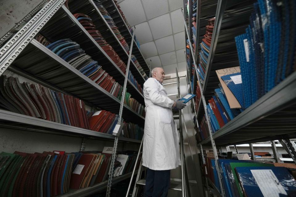 A worker checks surfaces portion of athletics tracks, at the Mondo factory, in Alba, northern Italy, Wednesday, March 13, 2024. The athletics track for the upcoming Paris Olympics is being produced by the Mondo company at its factory in northern Italy. The track is made in portions, rolled up and then will be transported to the Stade de France, where it will be installed over the next month. (AP Photo/Luca Bruno)