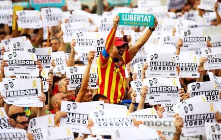 People wave placards which read "Freedom for the Jordis" and "We want them home" in Catalan during a demonstration organised by Catalan pro-independence movements ANC (Catalan National Assembly) and Omnium Cutural, following the imprisonment of their two leaders Jordi Sanchez and Jordi Cuixart, in Barcelona, Spain, October 21, 2017. REUTERS/Ivan Alvarado