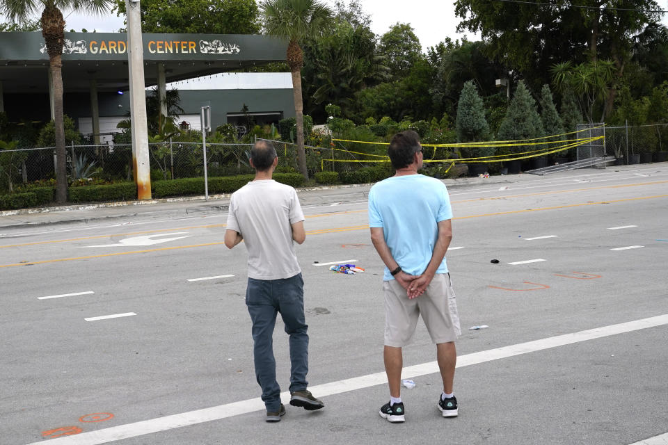 People look at the site where a driver slammed into spectators at the start of a Pride parade Saturday evening, killing one man and seriously injuring another, Sunday, June 20, 2021, in Fort Lauderdale, Fla. Officials said the crash was an accident, but it initially drew speculation that it was a hate crime directed at the gay community. The driver and victims were all members of the Fort Lauderdale Gay Men's Chorus, who were participating in the Wilton Manors Stonewall Pride Parade. (AP Photo/Lynne Sladky)