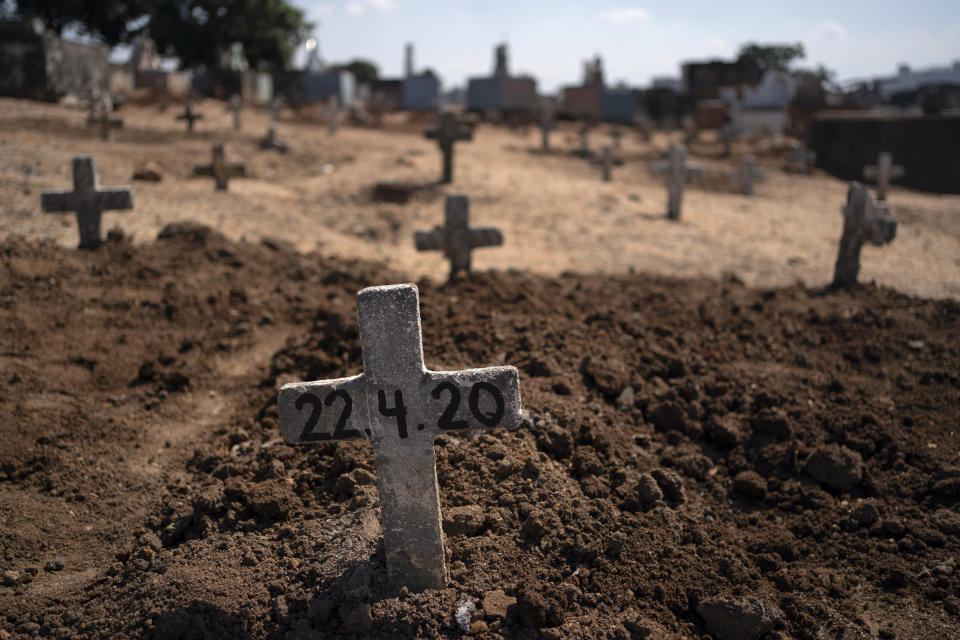 A cross with the date 22-4-20 marks the burial site of Edenir Rezende Bessa, who is suspected to have died of COVID-19, in Rio de Janeiro, Brazil, Wednesday, April 22, 2020. After visiting 3 primary care health units she was accepted in a hospital that treats new coronavirus cases, where she died on Tuesday. (AP Photo/Leo Correa)