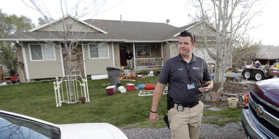 Pleasant Grove Police investigate the scene where seven infant bodies were discovered and packaged in separate containers at a home in Pleasant Grove, Utah, Sunday, April 13, 2014. According to the Pleasant Grove Police Department, seven dead infants were found in the former home of Megan Huntsman, 39. Huntsman was booked into jail on six counts of murder. (APPhoto/Rick Bowmer)