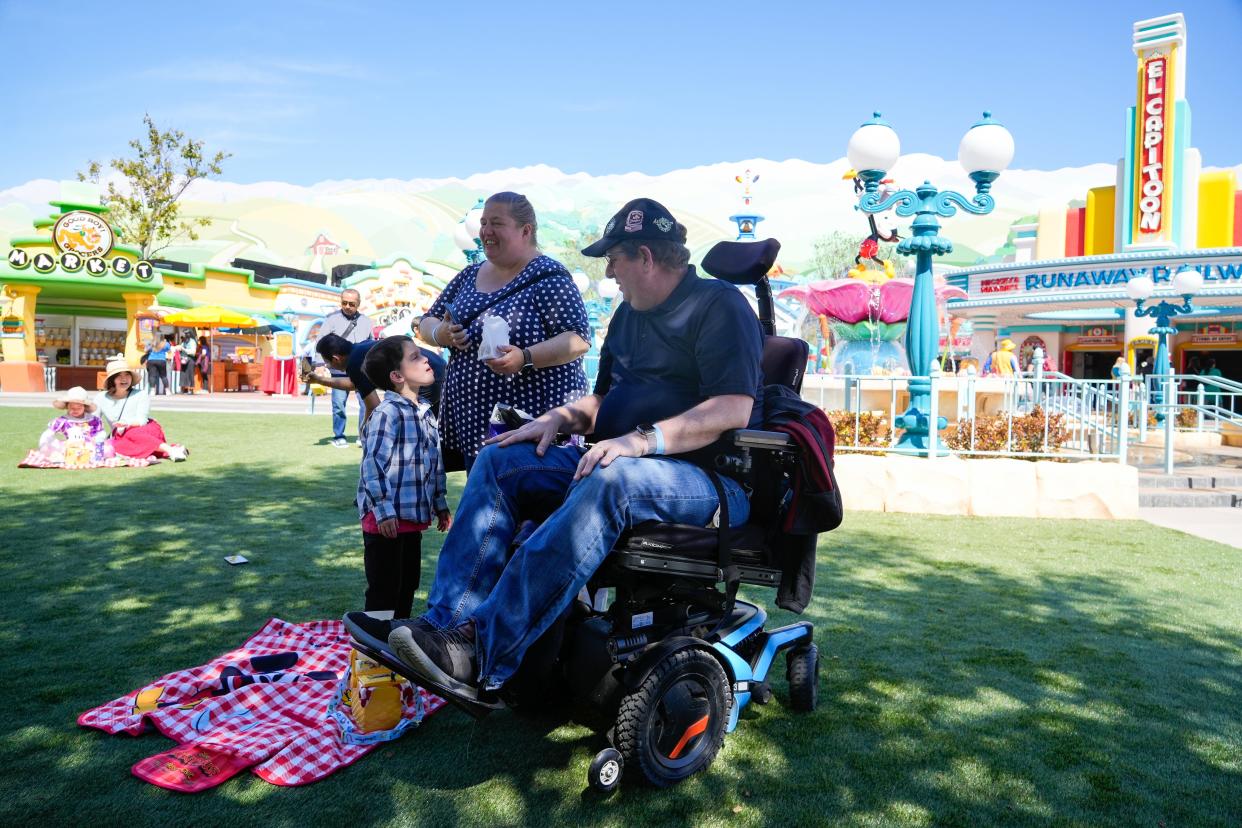 Adrienne Vincent-Phoenix (middle), Tony Phoenix (right) and their son Gabriel (left), take a break in CenTOONial Park, a grassy area inside of Mickey’s Toontown at Disneyland. The land reopened to the public on March 19 after undergoing a revamp to become more accessible to guests of all abilities.