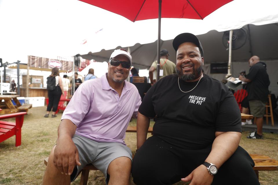 Ronald Payne of Payne’s Bar-B-Q, who was named a Kingsford Preserve the Pit fellow, sits on a bench next to his mentor Pat Neely of Neely's BBQ in the Kingsford booth area on May 19, 2023, during the Memphis in May World Championship Barbecue Cooking Contest at Tom Lee Park in Downtown Memphis.