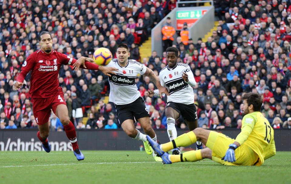 Liverpool’s Virgil van Dijk under pressure from Fulham’s Aleksandar Mitrovic and Ryan Sessegnon