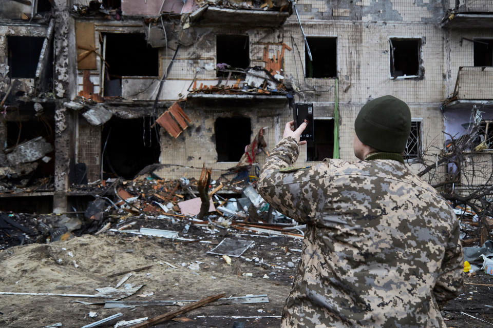 A Ukrainian soldier speaks on his smartphone outside a residential building damaged by a missile in Kyiv, Ukraine, on Feb. 25, 2022.<span class="copyright">Pierre Crom—Getty Images</span>