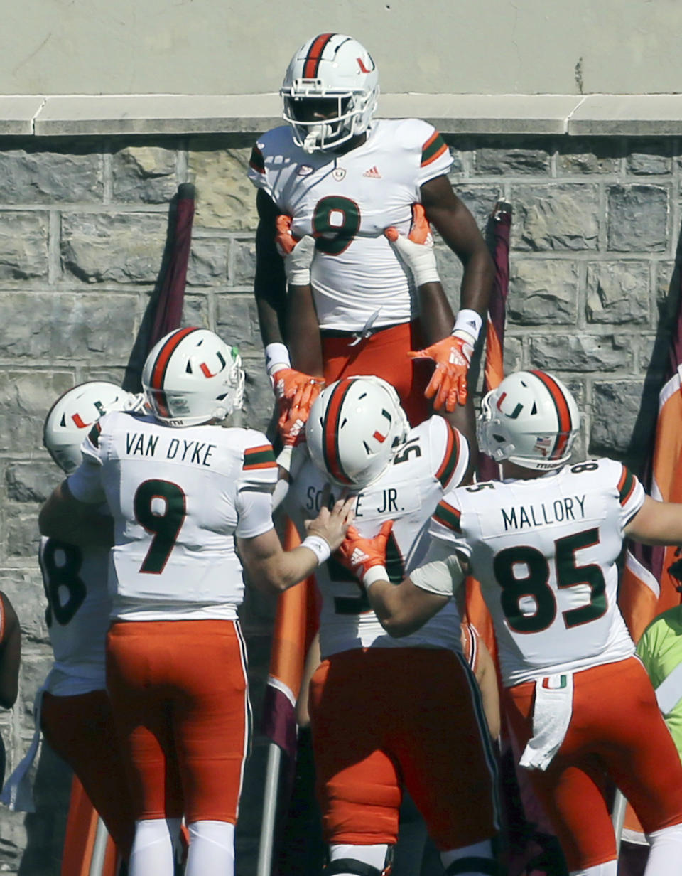 Miami's Frank Ladson (8) celebrates with teammates catching a touchdown pass during the first half during the first half of an NCAA football game against Virginia Tech, Saturday Oct. 15 2022, in Blacksburg Va. (Matt Gentry/The Roanoke Times via AP)