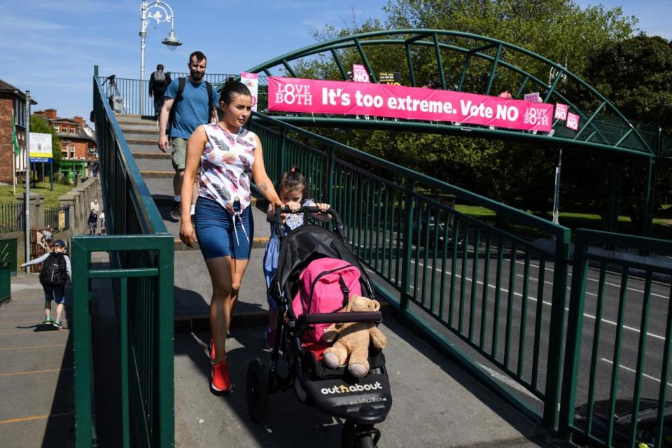 A mother pushes a pram past a placard for the NO campaign in Dublin (Getty Images)