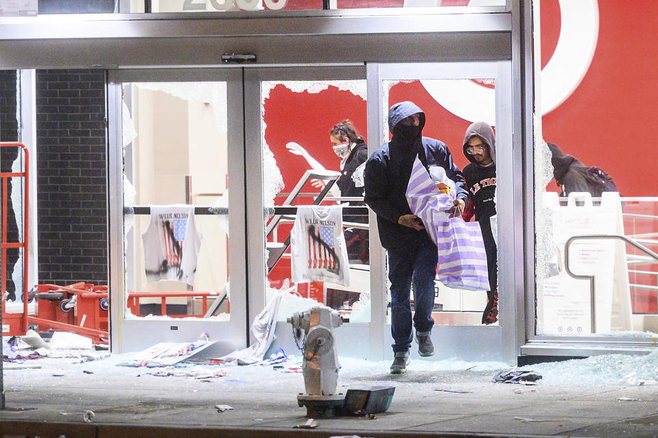 People leave a vandalized Target store in Oakland, Calif., on Saturday, May 30, 2020, during protests against the death of George Floyd, a handcuffed black man in police custody in Minneapolis. (AP Photo/Noah Berger)