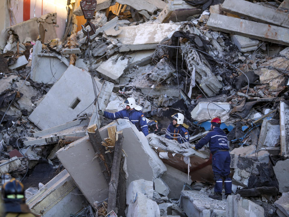 Emergency Situations employees working at the scene of a collapsed apartment building in Magnitogorsk, a city of 400,000 people, about 1,400 kilometers (870 miles) southeast of Moscow, Russia, Monday, Dec. 31, 2018. Russian emergency officials say that at least four people have died after sections of the apartment building collapsed after an apparent gas explosion in the Ural Mountains region. (AP Photo/Maxim Shmakov)