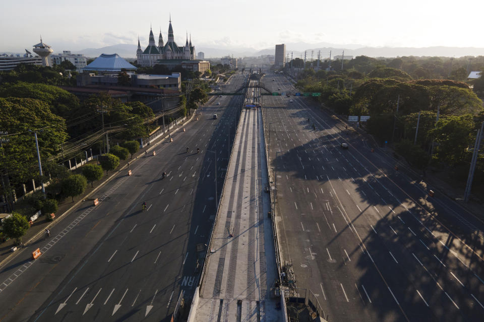 Motorist traverse an almost empty Commonwealth Avenue as the government implements a strict lockdown to prevent the spread of the coronavirus on Good Friday, April 2, 2021 in Quezon city, Philippines. Filipinos marked Jesus Christ's crucifixion Friday in one of the most solemn holidays in Asia's largest Catholic nation which combined with a weeklong coronavirus lockdown to empty Manila's streets of crowds and heavy traffic jams. Major highways and roads were eerily quiet on Good Friday and churches were deserted too after religious gatherings were prohibited in metropolitan Manila and four outlying provinces. (AP Photo/Aaron Favila)