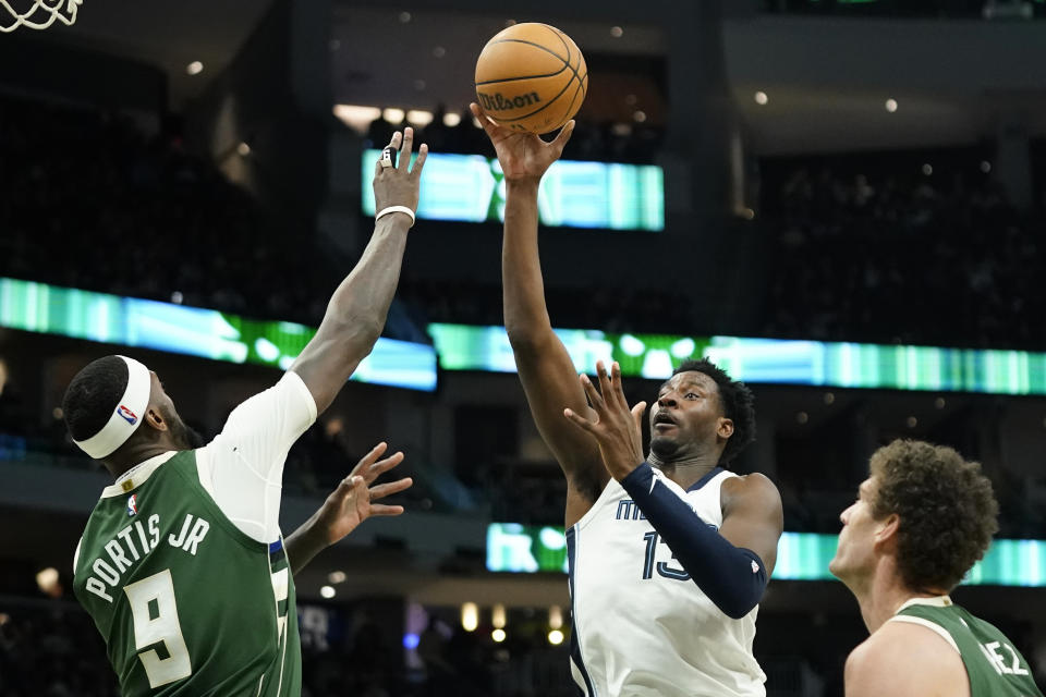 Memphis Grizzlies' Jaren Jackson Jr., middle, shoots against Milwaukee Bucks' Bobby Portis (9) and Brook Lopez during the second half of an NBA basketball game Wednesday, April 3, 2024, in Milwaukee. (AP Photo/Aaron Gash)