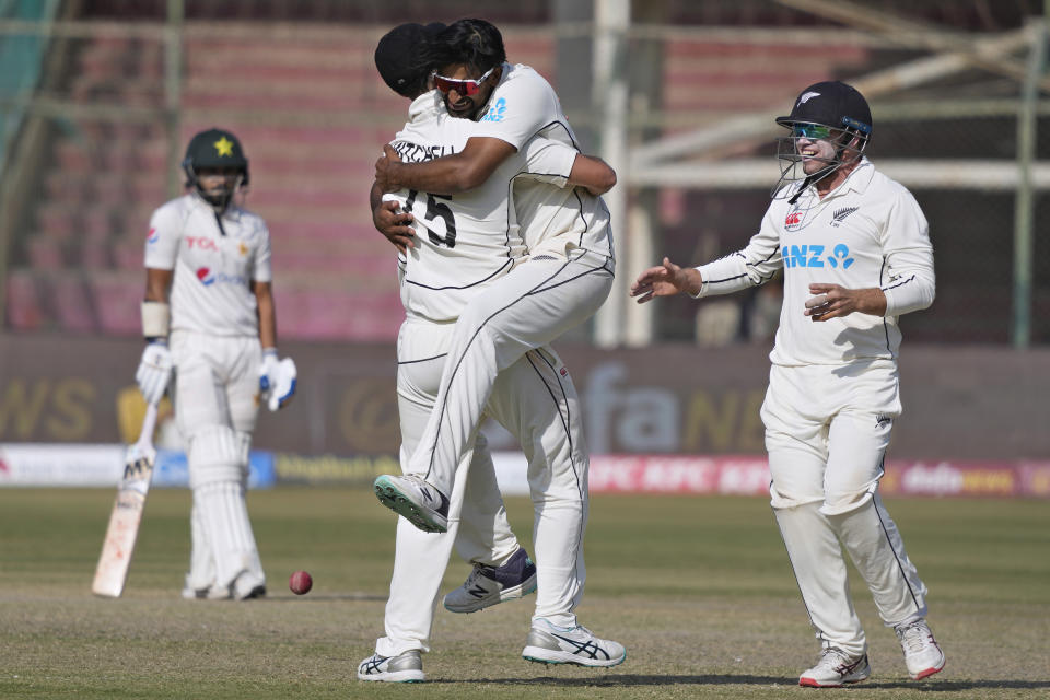 New Zealand's Ish Sodhi, center, celebrates with teammates after taking the wicket of Pakistan's Imam-ul-Haq during the fifth day of first test cricket match between Pakistan and New Zealand, in Karachi, Pakistan, Friday, Dec. 30, 2022. (AP Photo/Fareed Khan)