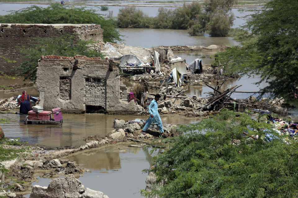 A man looks for salvageable belongings from his flood-damaged home in the Shikarpur district of Sindh Province, Pakistan, Thursday, Sept. 1, 2022. Pakistani health officials on Thursday reported an outbreak of waterborne diseases in areas hit by recent record-breaking flooding, as authorities stepped up efforts to ensure the provision of clean drinking water to hundreds of thousands of people who lost their homes in the disaster. (AP Photo/Fareed Khan)