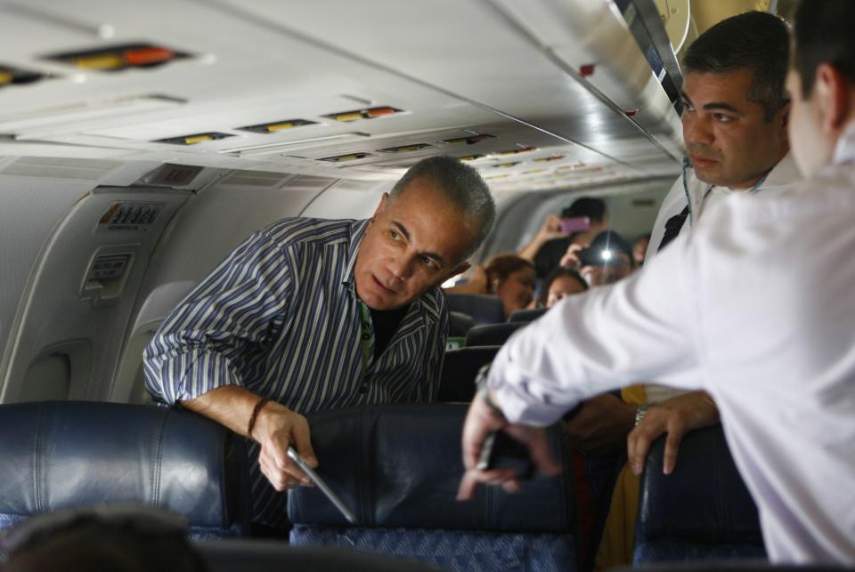 FILE - In this Oct. 15, 2015 file photo, Venezuelan opposition leader Manuel Rosales, left, prepares to deplane at La Chinita airport in Maracaibo, Venezuela. The former governor and presidential candidate who was arrested after deplaning, was returning from exile in Peru, where he fled to escape charges of stealing public funds that he says were politically motivated. He is currently under house arrest awaiting trial. (AP Photo/Jhair Torres, File)