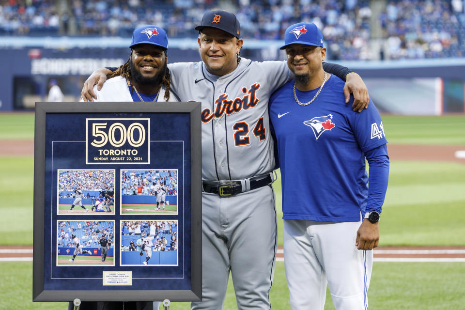 Detroit Tigers designated hitter Miguel Cabrera (24) stands with Toronto Blue Jays' Vladimir Guerrero Jr., left, and Victor Martinez as he is honored by the Blue Jays organization for hitting his 500th career home run in Toronto last season, ahead of a baseball game in Toronto on Thursday, April 13, 2023. (Cole Burston/The Canadian Press via AP)