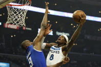 Minnesota Timberwolves forward Jarred Vanderbilt, right, shoots as Los Angeles Clippers center Serge Ibaka defends during the first half of an NBA basketball game Monday, Jan. 3, 2022, in Los Angeles. (AP Photo/Mark J. Terrill)