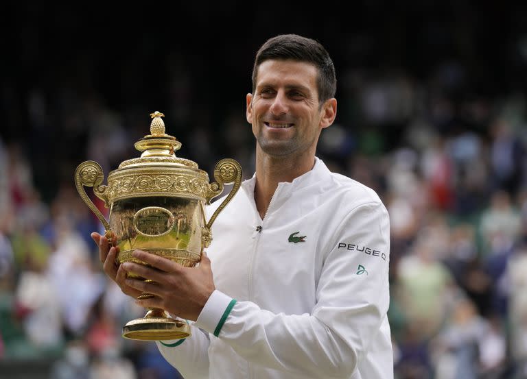 El serbio Novak Djokovic sostiene el trofeo de los ganadores mientras posa para los fotógrafos después de derrotar al italiano Matteo Berrettini en la final masculina individual el día trece del Campeonato de Tenis de Wimbledon en Londres, el domingo 11 de julio de 2021